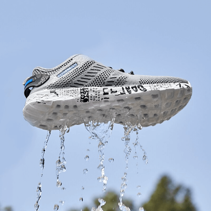 Gray men's casual lace-up mesh sneakers with water-resistant soft outsole, against a blue sky. Perfect for stylish comfort.